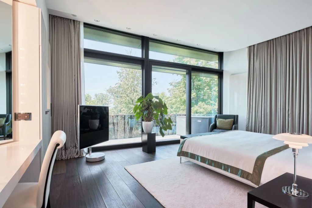 Helles Zimmer mit großem Fensterblick, modernem Design und Pflanzenakzent