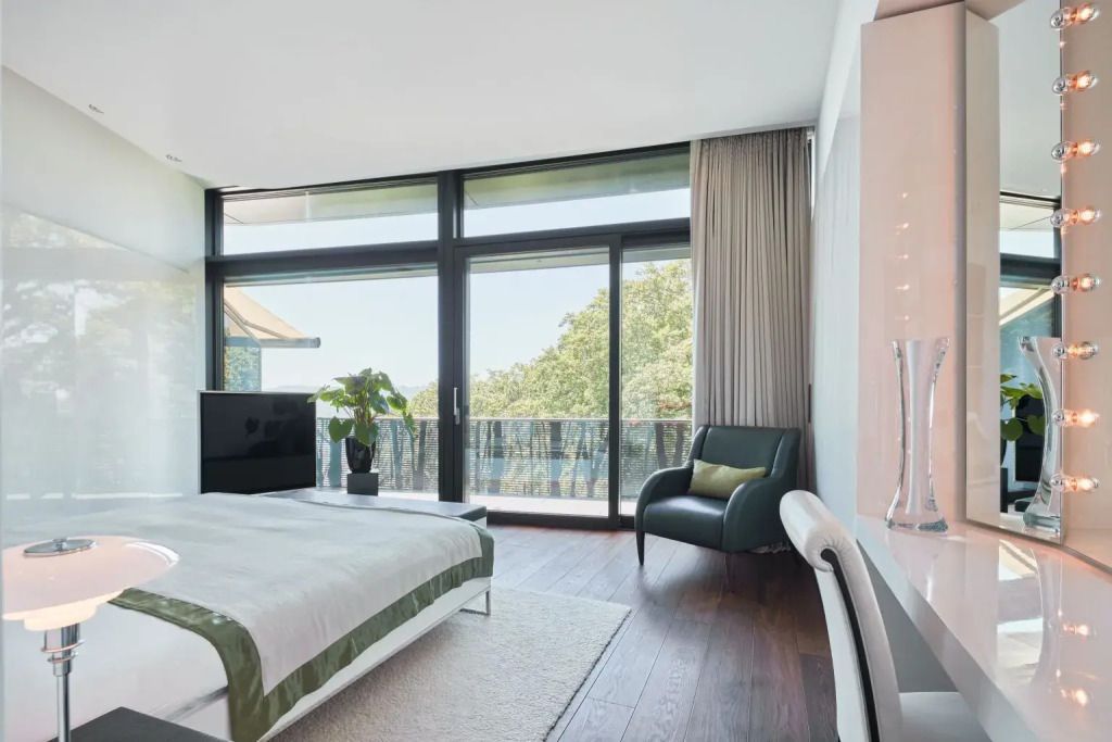 Schlafbereich mit großem Fenster und Balkonausblick in stilvollem Design
