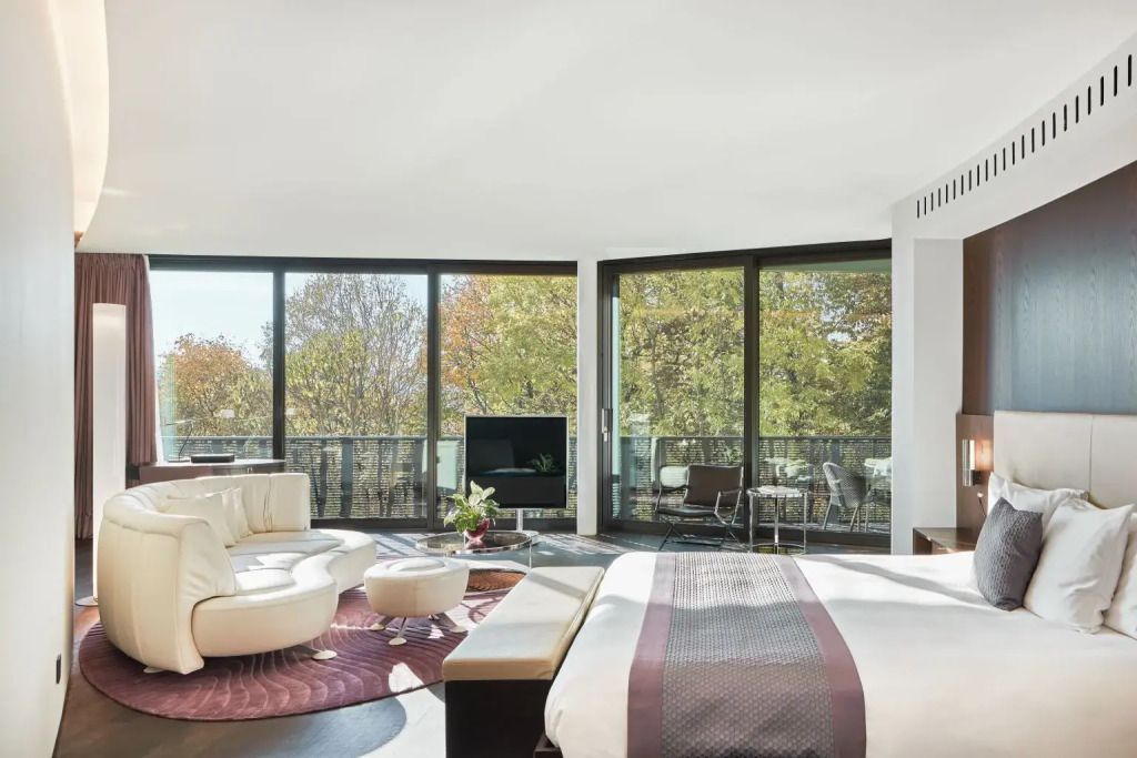 Moderne Junior-Suite mit Glasfront und Blick ins Grüne