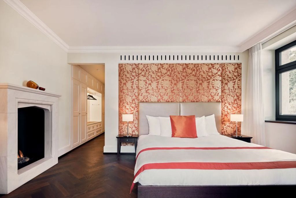 Helles Schlafzimmer mit Doppelbett und eleganter Tapete in der Dolder Grand Suite