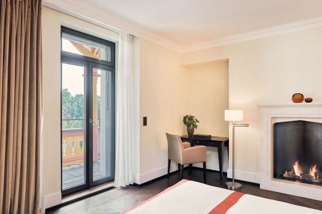 Zimmer mit Schreibtisch und Zugang zum Balkon im Dolder Grand