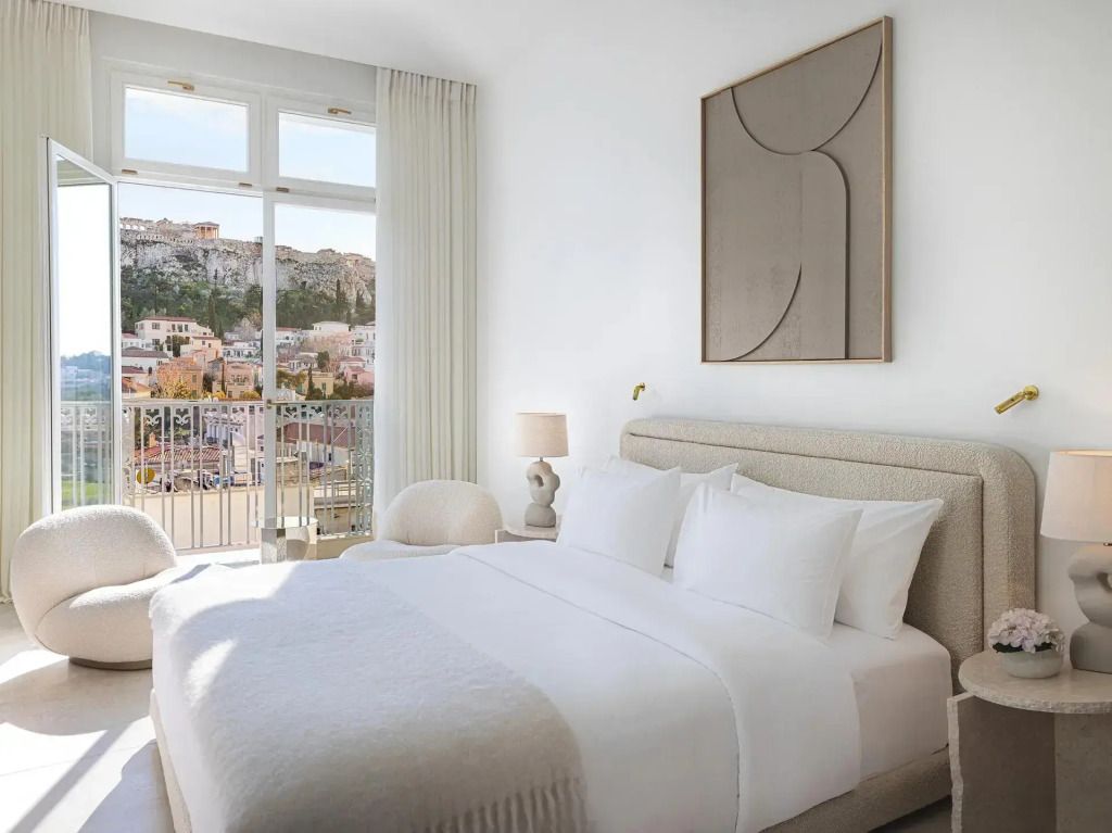Gemütliches Doppelbett mit Aussicht auf Stadt und Akropolis durch großes Fenster.