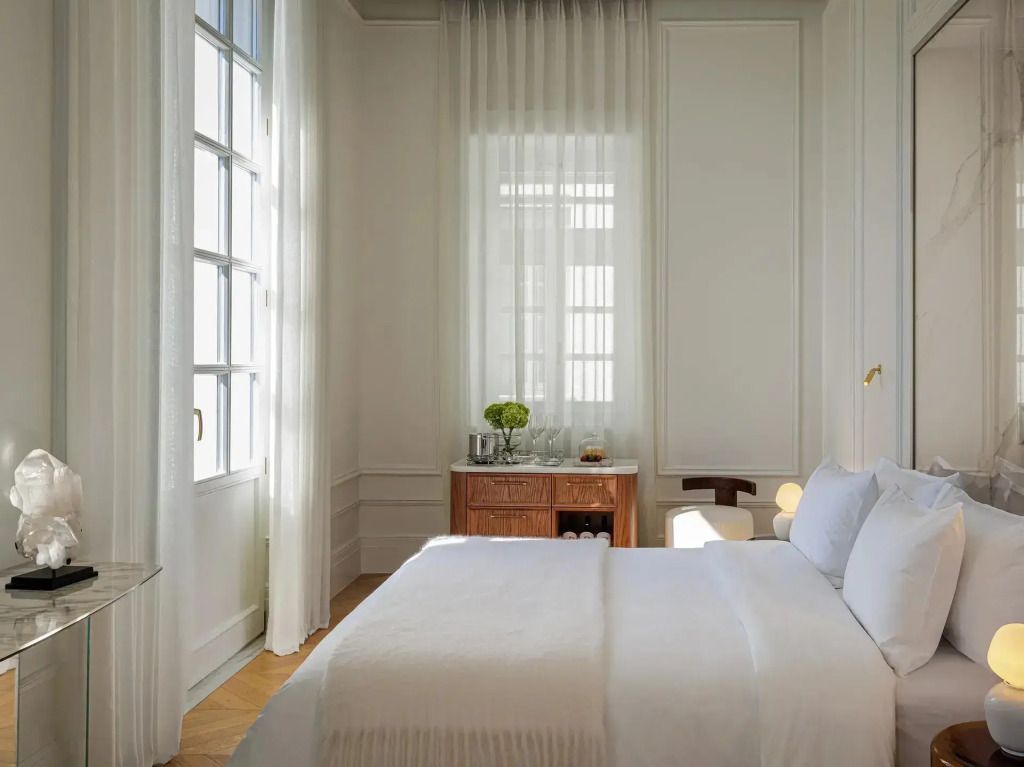 Helles Schlafzimmer mit großem Fenster, Doppelbett und hellem Vorhang