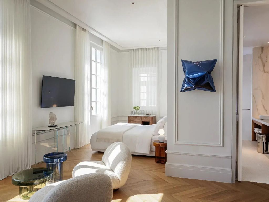 Moderner Wohnbereich mit Fernseher, skulpturalem Stuhl und Dekoelement