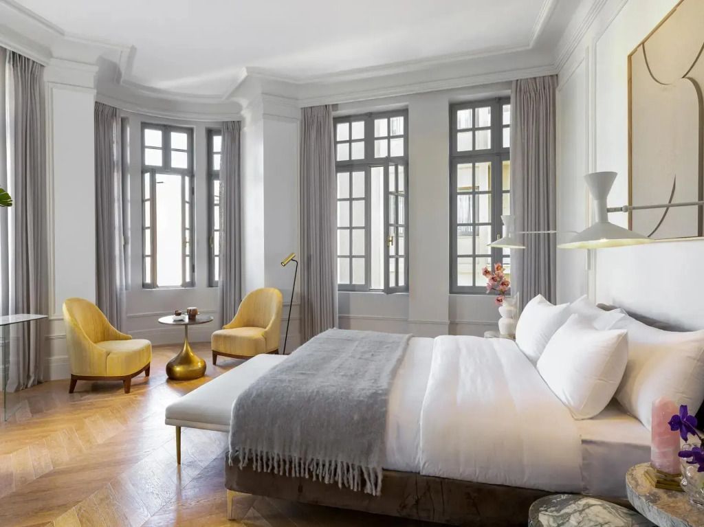 Geräumiges Schlafzimmer mit eleganten Sesseln und großen Fenstern