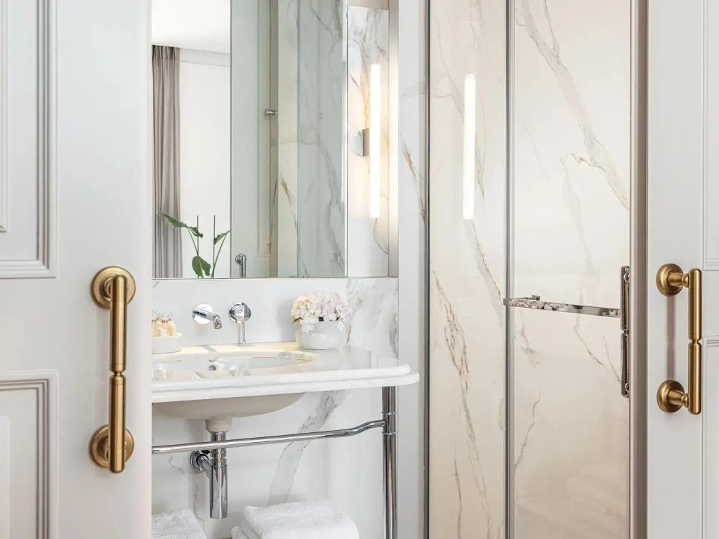 Helles Badezimmer mit marmornem Waschtisch und Dusche
