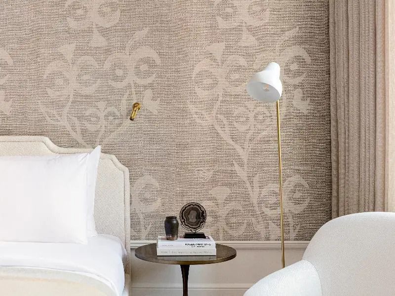 Detailansicht des Bettes im Hotelzimmer mit Leselampen und Beistelltisch