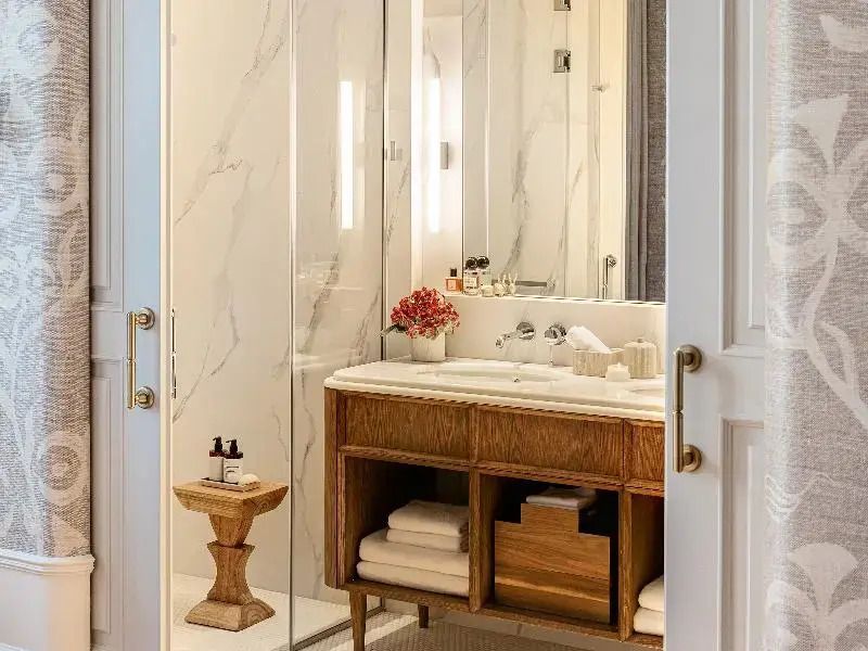 Marmorbad im Hotelzimmer mit eleganter, hölzerner Badezimmerelementen und frischen Handtüchern