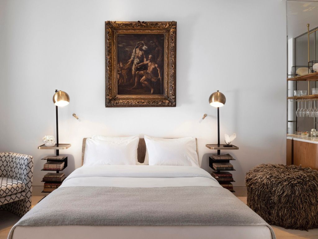 Gemütliches Schlafzimmer mit Kunstwerk über dem Bett und Designerleuchten