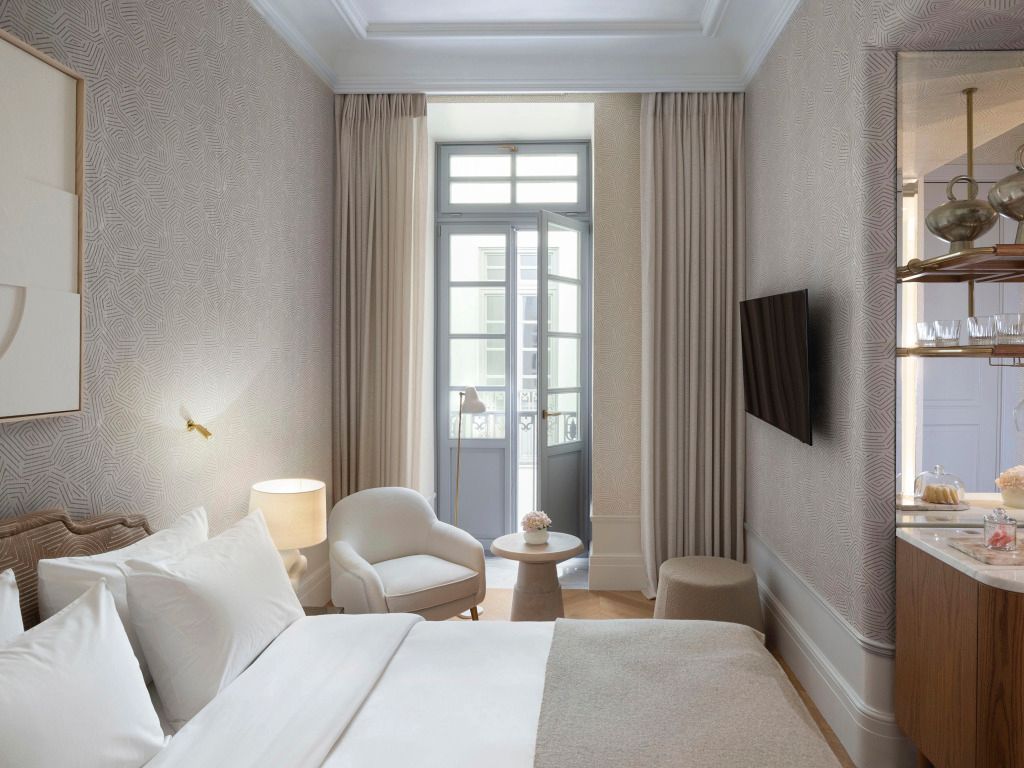 Helles Schlafzimmer mit französischem Balkon und entspannendem Sitzbereich
