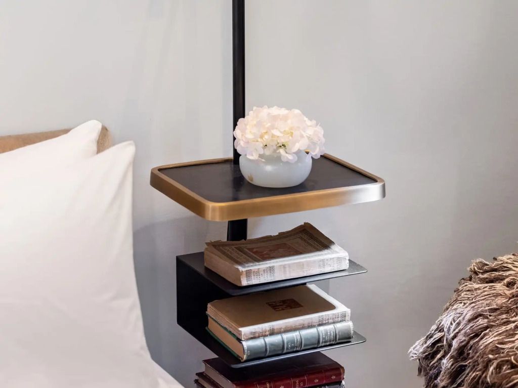 Nachttisch mit dekorativen Büchern und frischen Blumen
