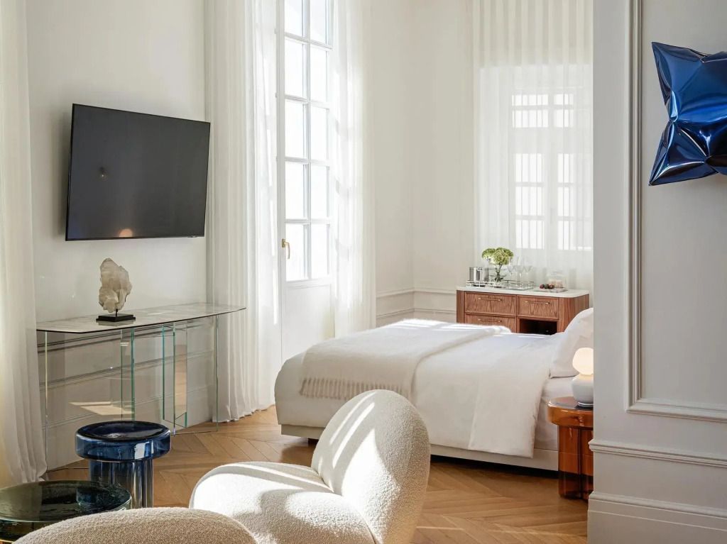 Helles Schlafzimmer mit TV und modernem Sitzbereich