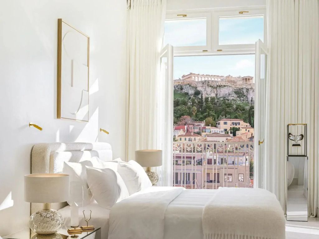 Komfortables Doppelbett in Suite mit offenem Fenster und Akropolis-Blick