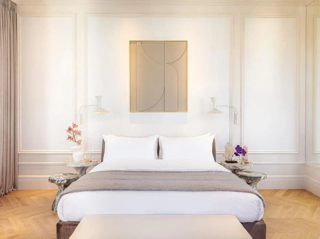 Elegantes Doppelbett mit hochwertiger Bettwäsche und Wandkunst in der Junior-Suite.