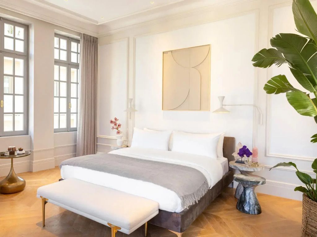 Geräumige Junior-Suite mit Doppelbett, eleganten Vorhängen und moderner Kunst an der Wand.