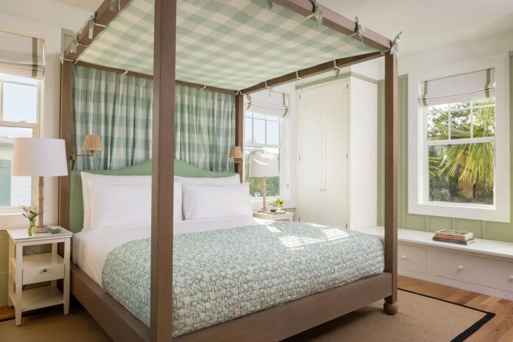 Zimmer mit Himmelbett und großen Fenstern, sonnendurchflutet