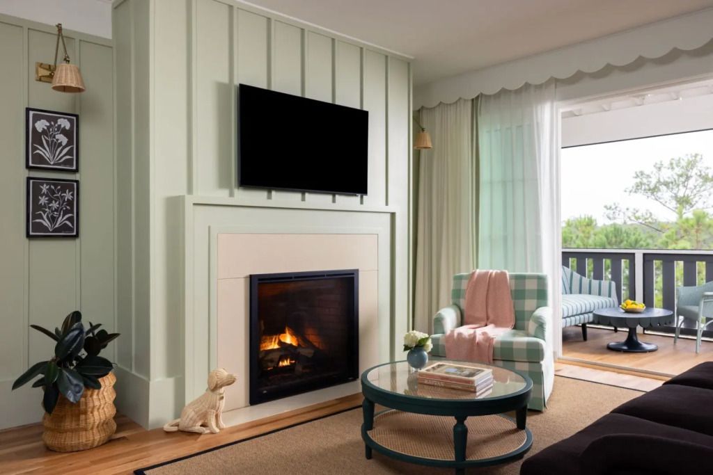 Wohnbereich mit Kamin und kleinem Tisch in eleganter Suite