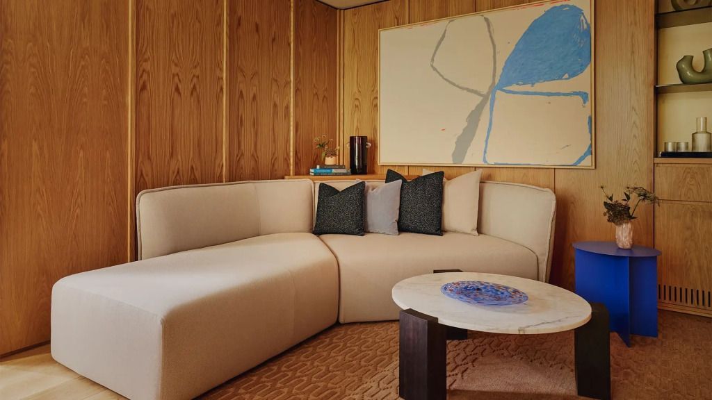 Gemütlicher Wohnbereich mit Sofa und moderner Kunst an der Wand.