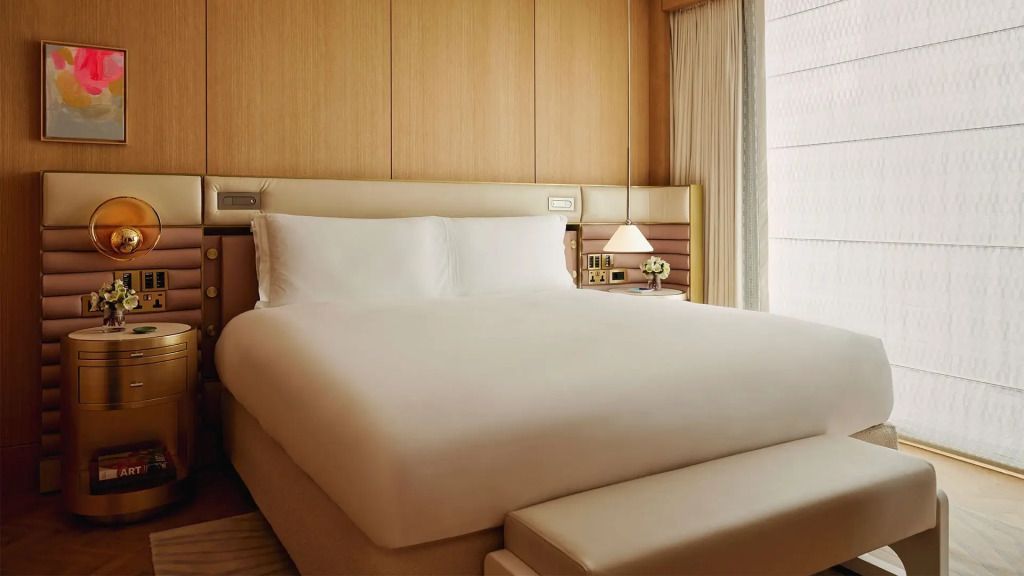 Geräumiges Doppelzimmer mit elegantem Bett und cremefarbener Einrichtung