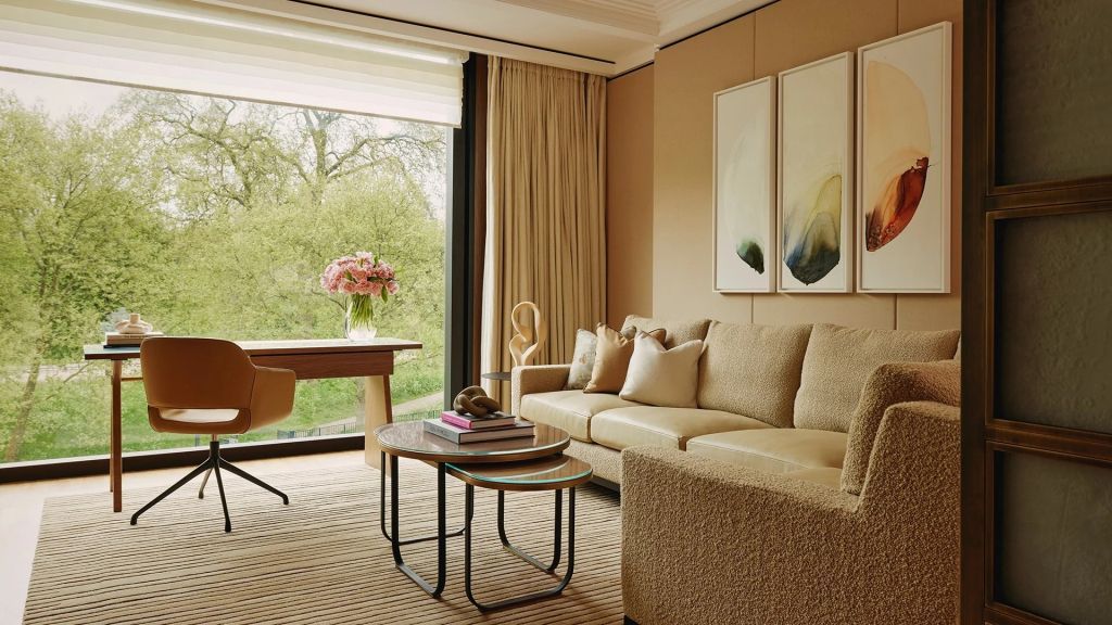 Wohnbereich mit Designer-Sofa und großer Fensterfront mit Parkblick
