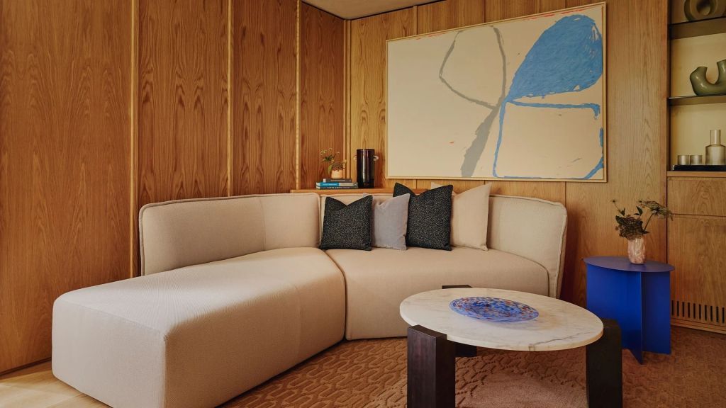 Moderne Sitzecke mit beigem Sofa und abstrakter Kunst an der Wand