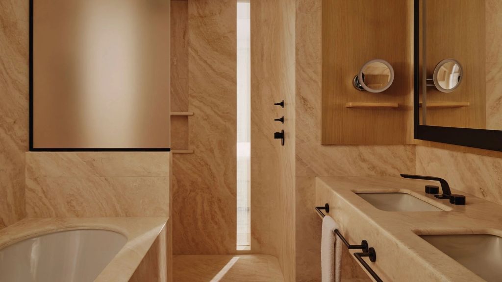 Luxuriöses Badezimmer mit Marmorverkleidung und dezenter Beleuchtung
