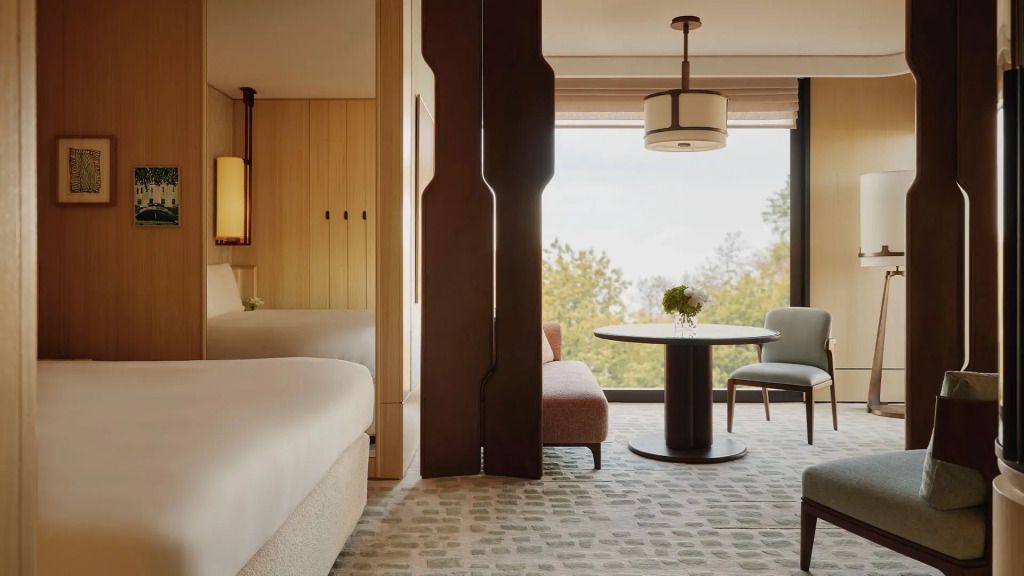 Junior Suite mit modernen Möbeln und Blick auf Bäume durch große Fenster