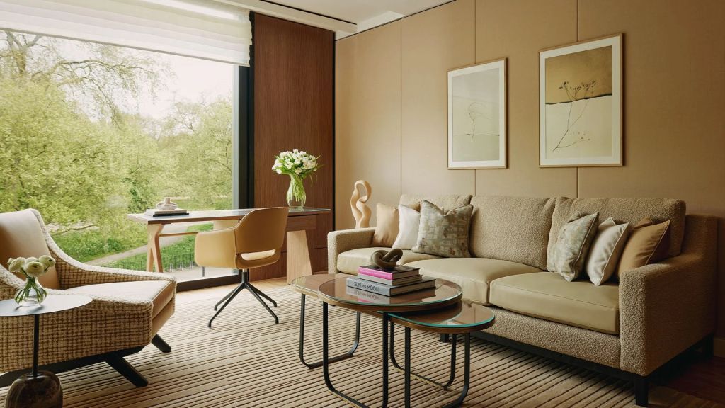 Lounge mit bequemen Sofas, Kunstwerken und großem Fenster mit Gartenblick.
