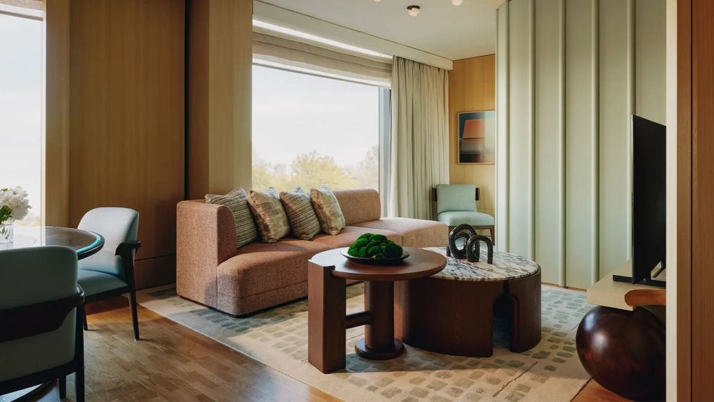 Gemütlicher Wohnbereich mit eleganter Sofagruppe und großem Fenster im The Emory Suite.