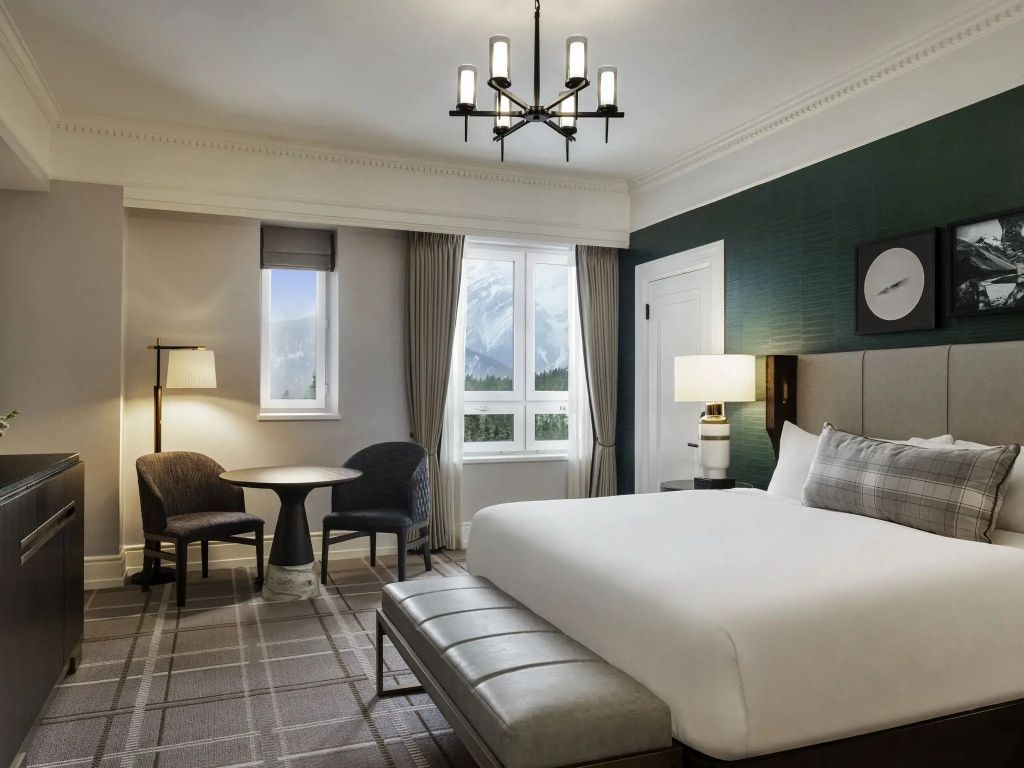 Modernes Deluxe Doppelzimmer mit Sitzbereich und Blick auf die Berge im Fairmont Banff Springs.