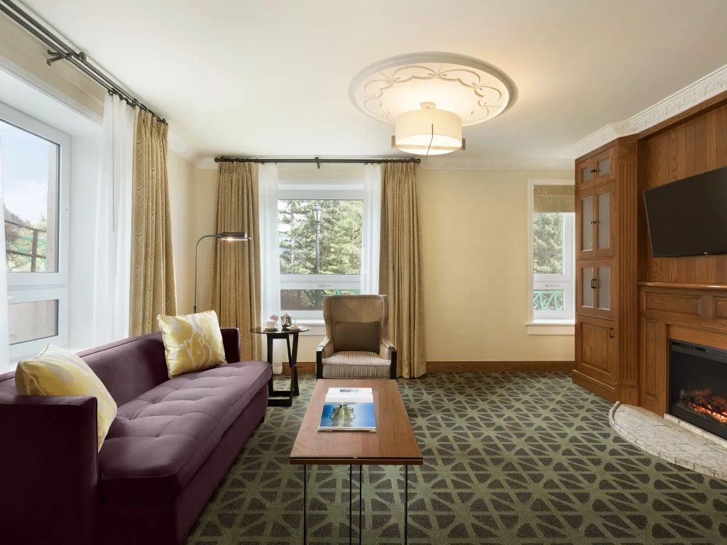 Geräumiges Wohnzimmer mit Sofa, Beistelltisch und Blick auf die Berge durch große Fenster