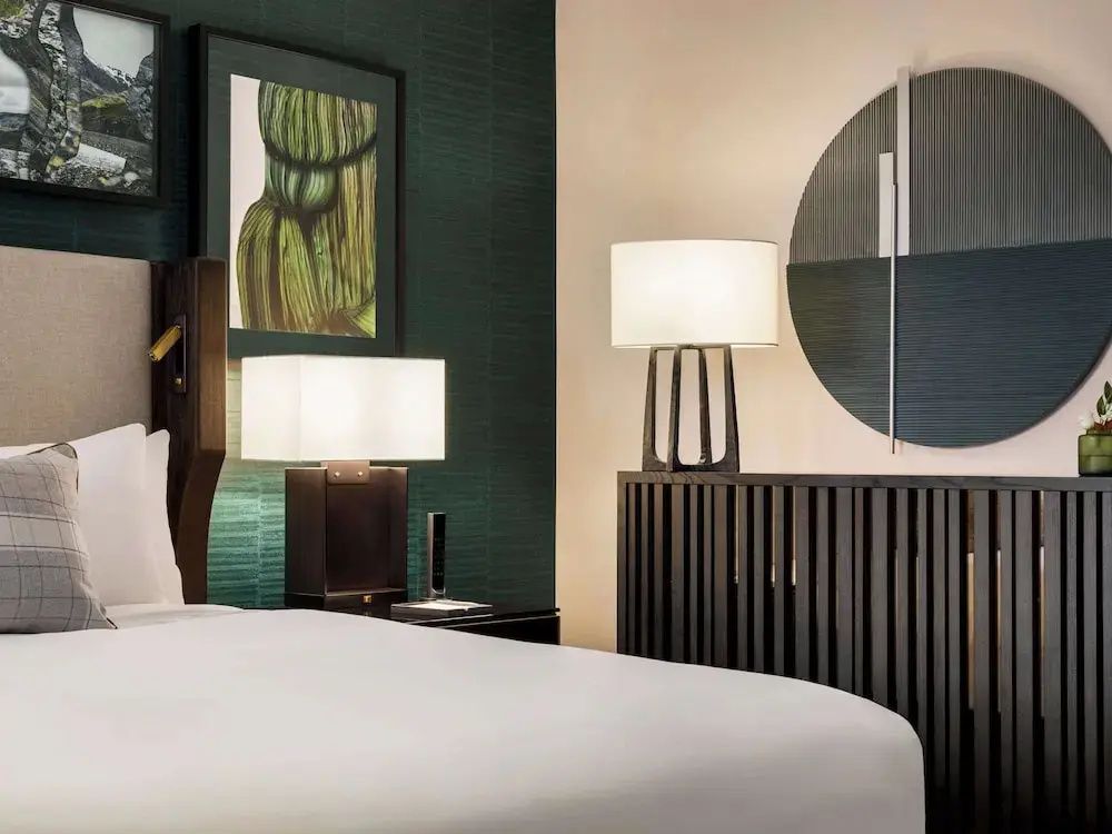Modernes Schlafzimmer mit stilvollem Dekor, Kunst an der Wand und eleganten Lampen