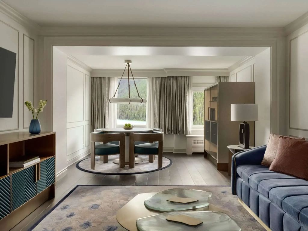 Essbereich der Belvedere Suite mit modernem Tisch und Ausblick auf bewaldete Hügel.