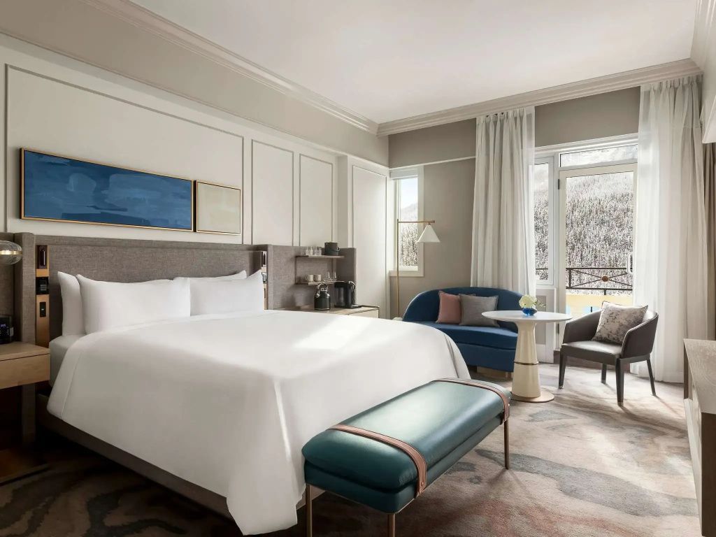 Deluxe Doppelzimmer mit stilvollen Möbeln und großen Fenstern mit Seeblick