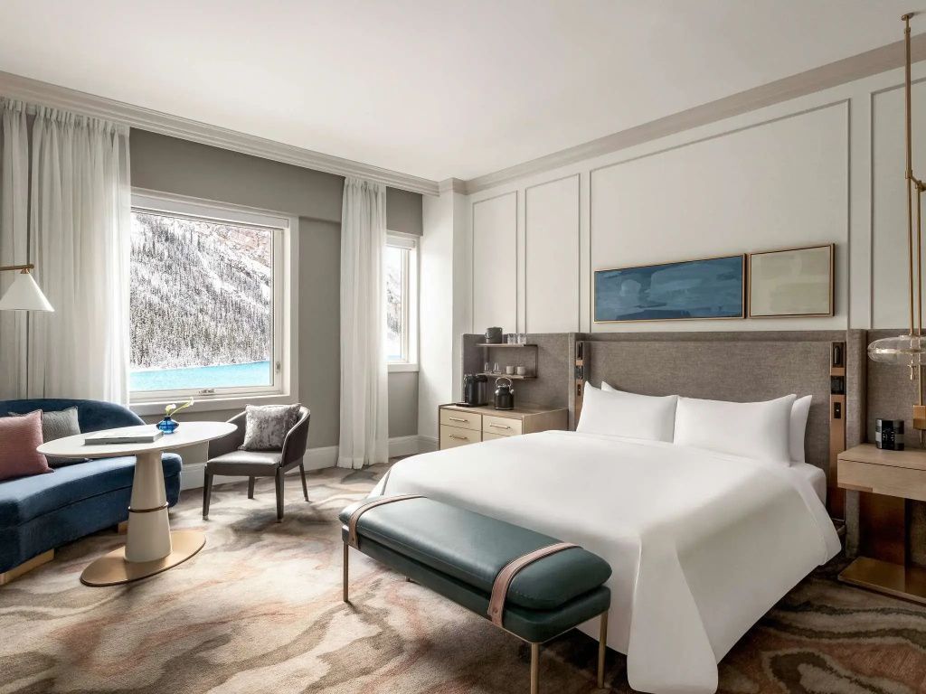 Helles Deluxe Doppelzimmer mit Blick auf den verschneiten See und stilvollem Interieur