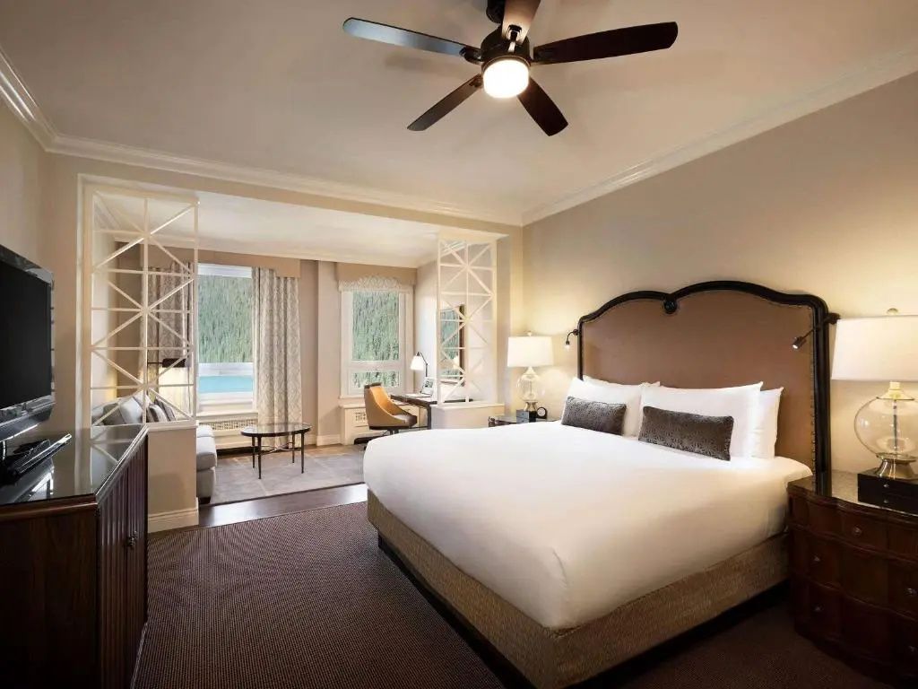 Geräumige Suite mit Doppelbett und Deckenventilator sowie großen Fenstern