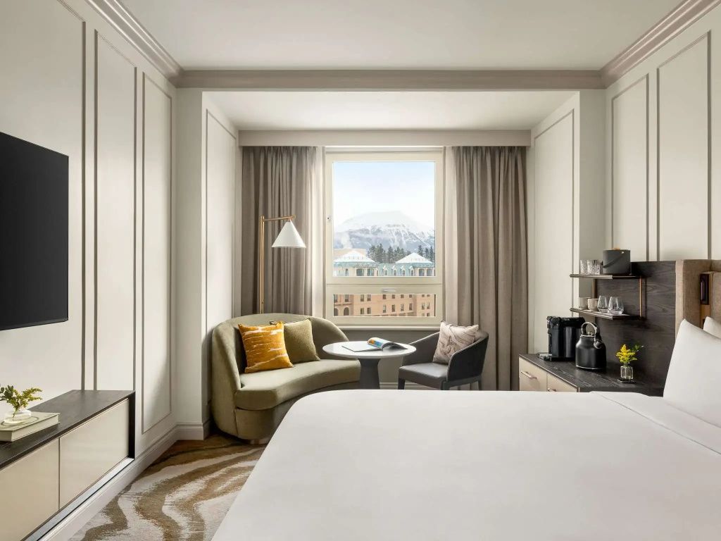 Fairmont Doppelzimmer mit Bergblick, gemütlicher Sessel und Tisch vor Fenster.