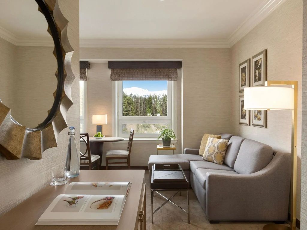 Elegant eingerichtetes Wohnzimmer der Junior-Suite mit Sofa und Blick auf den Wald