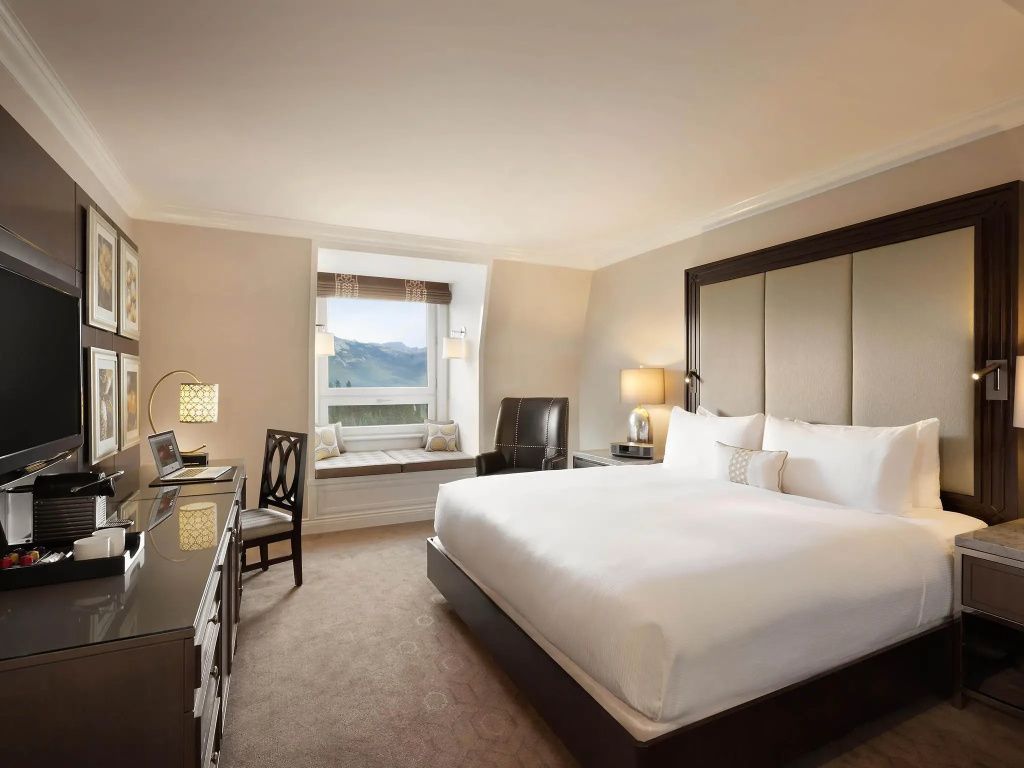 Elegantes Doppelzimmer mit luxuriösem Doppelbett und Blick auf die Berge