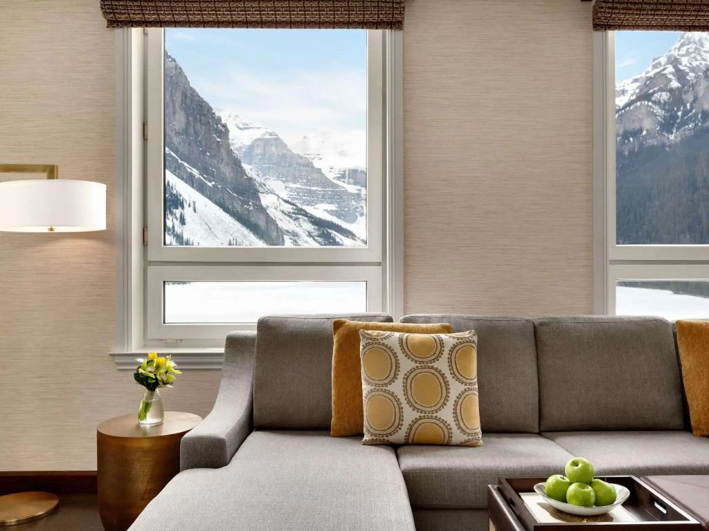 Wohnbereich mit Sofa und Panoramafenster zum Bergblick