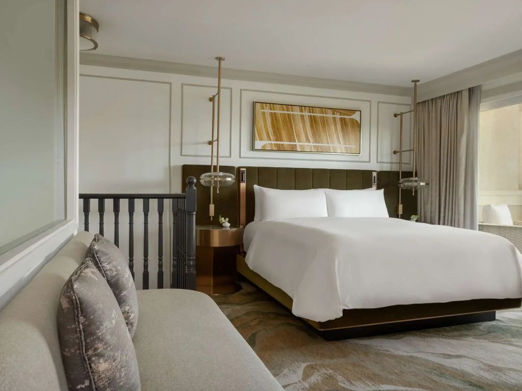 Gemütliches Bett in der Fairview Suite mit stilvoller Beleuchtung und Dekor