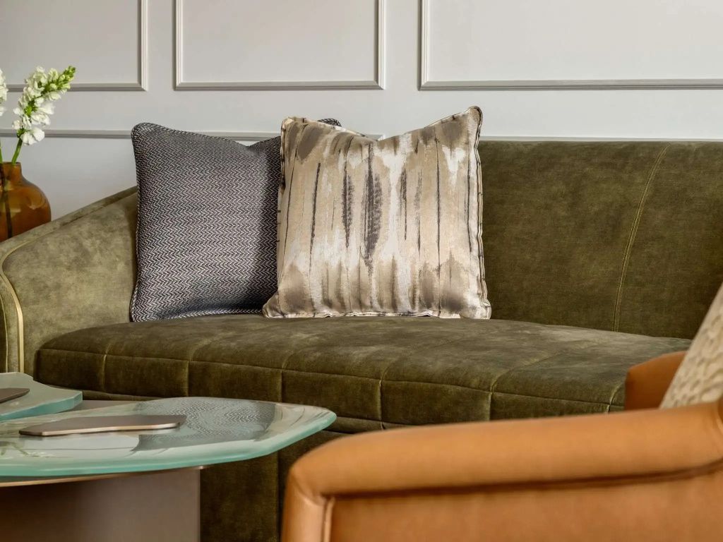 Gemütliche Sofa-Ecke mit dekorativen Kissen in der Fairview Suite