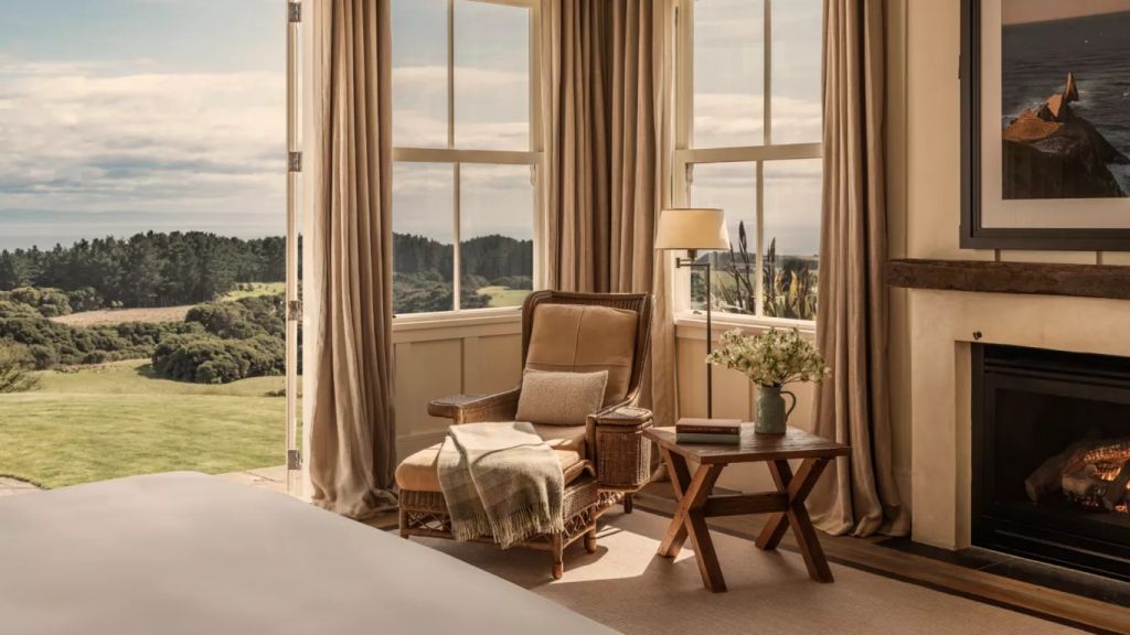 Gemütlicher Lesesessel mit Aussicht auf die Landschaft vor großen Fenstern.