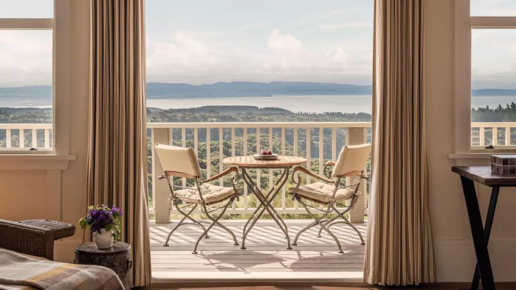 Balkon mit Tisch und Stühlen bietet grandiosen Ausblick auf Hügel und Meer