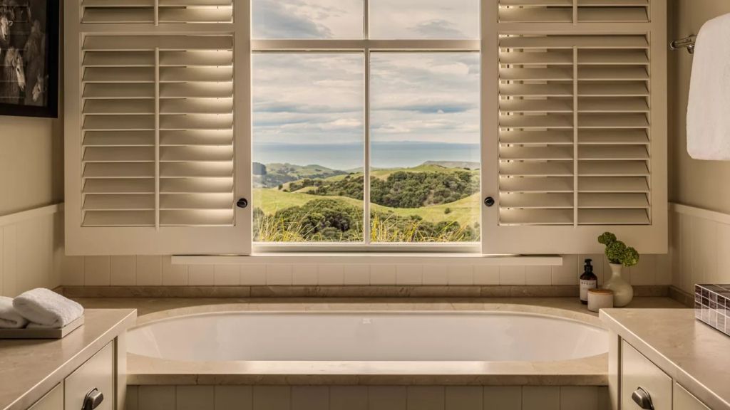 Luxuriöse Badewanne mit Blick auf die grüne Landschaft und das entfernte Meer