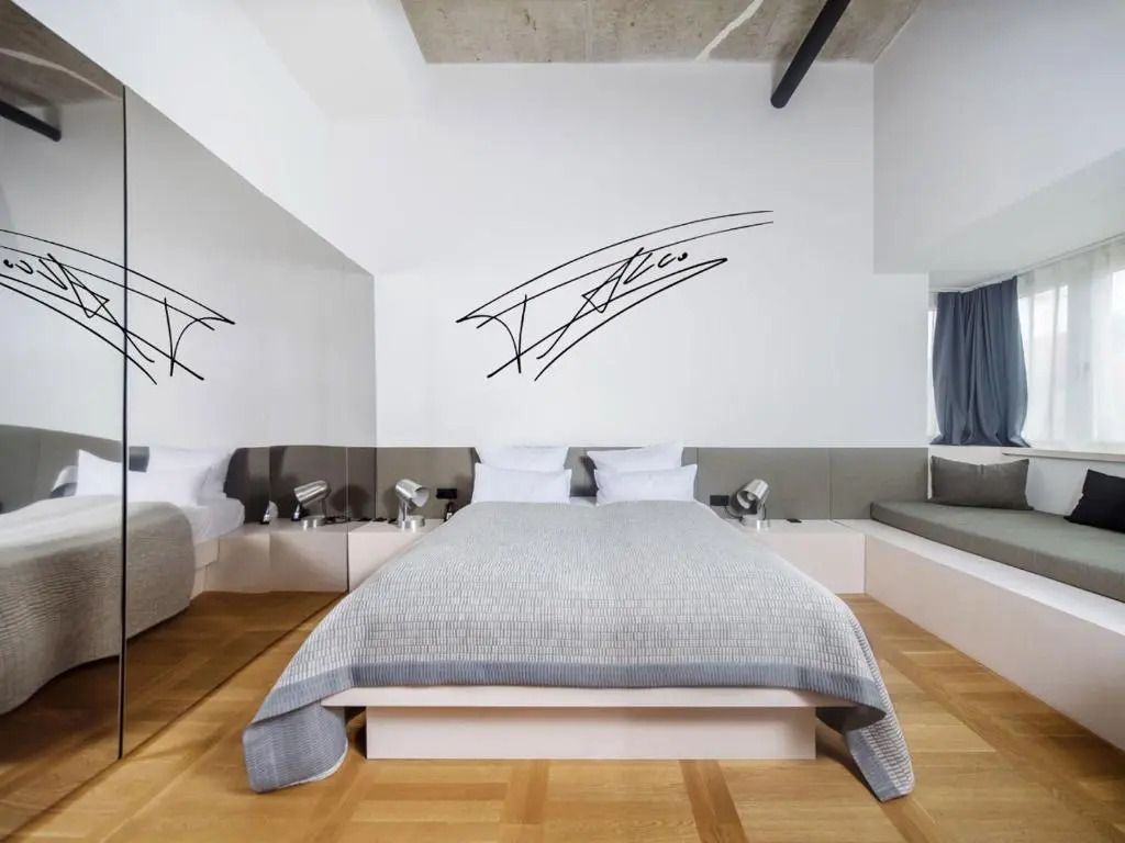 Modernes Hotelzimmer mit einem großen Bett und minimalistischer Wanddekoration