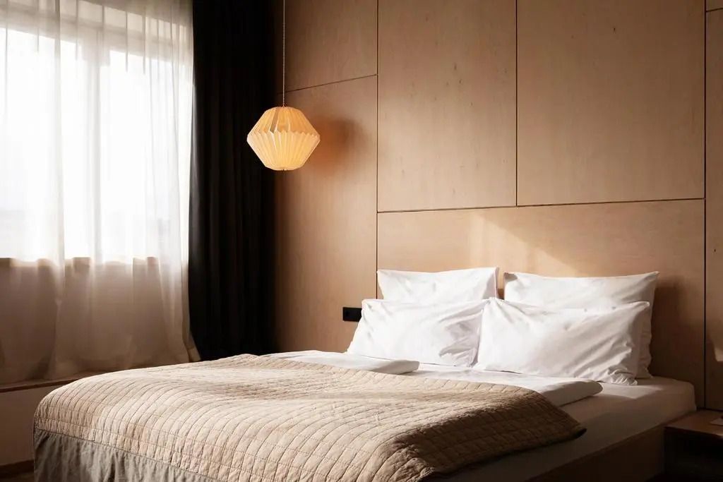 Schlichtes Schlafzimmerdesign mit natürlichem Licht und hölzerner Wandverkleidung