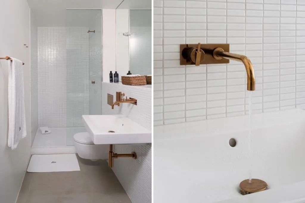Modernes Badezimmer mit weißen Fliesen und goldenen Armaturen
