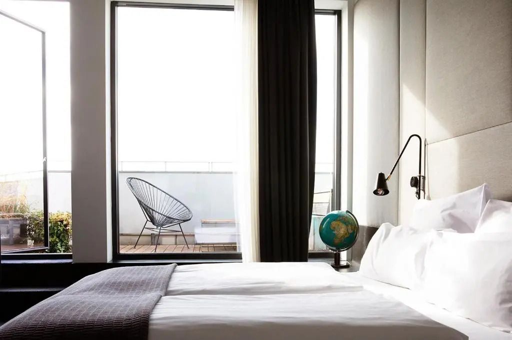 Lichtdurchflutetes Zimmer mit Einzelbett und Stadtblick