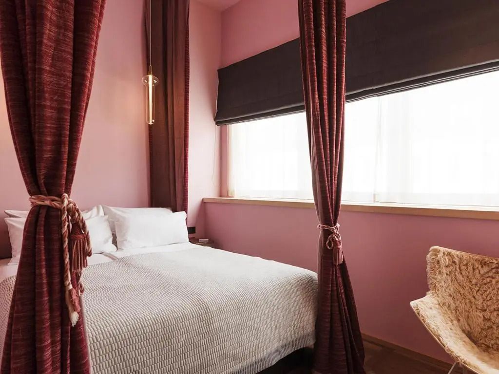 Zimmer mit rosa Wänden und weißen Vorhängen, stilvoll eingerichtet